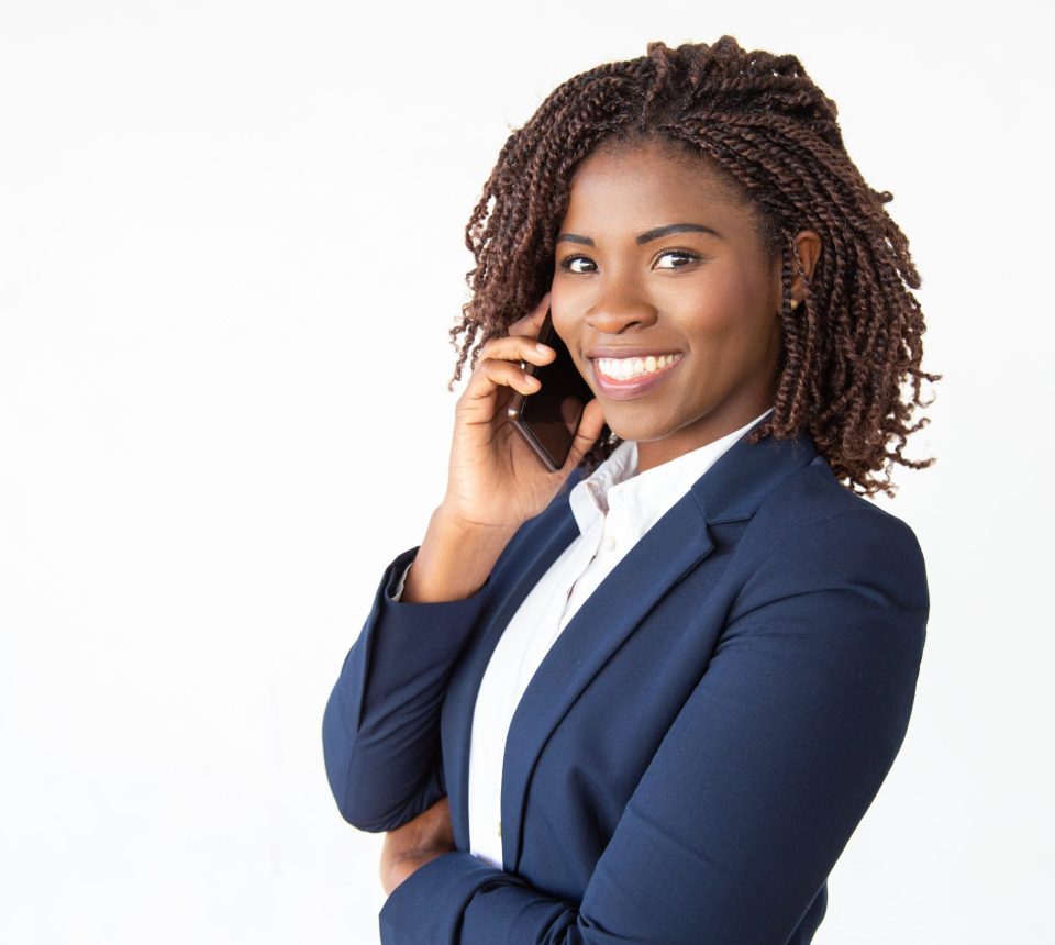 Happy successful consultant talking on mobile phone, looking at camera. Young African American business woman standing isolated over white background. Business communication concept